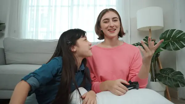 Caucasian smart mom playing game together with daughter for winning or clear game while planning strategy. Attractive mother and daughter spend time together while sitting at living room. Pedagogy.