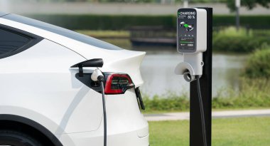 Green City Park 'taki otoparkta EV elektrikli araba şarj pili. Sürdürülebilir ve çevre dostu şehir yolculuğu için yenilenebilir otomobil için alternatif temiz enerji teknolojisi. Yararlı