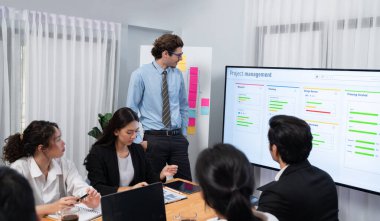 Proje yöneticisi toplantı odasında iş programları, Gantt program programı TV ekranında. Çoklu etnik çeşitlilik iş adamları ve modern iş projesi yönetimi. Habiliment