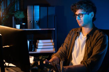 Genç işadamı, Neon Light Modern Ofis 'te yaratıcı bir başlangıç projesi için bilgisayara odaklanıyor. Düşünüyorum da, pazarlama ağı yaratıcıdan pazar kanalı tasarım konseptine çevrimiçi planlama. Toplayıcı.