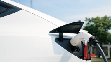 Green City Park 'taki otoparkta yavaş çekim EV elektrikli araba şarj bataryası. Sürdürülebilir ve çevre dostu şehir yolculuğu için yenilenebilir otomobil için alternatif temiz enerji teknolojisi. Yararlı