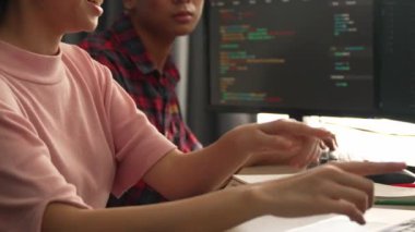 Yavaş çekim arkası yazılım geliştirici mühendisi bilgisayar programlama için birlikte çalışarak hata ayıklama kodunu çözüyor, ofiste monitörde karmaşık algoritmaları çözüyor. Filizlenen