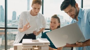 Akıllı mimar takımı ev tasarımı hakkında tartışırken yakışıklı erkek işçi dizüstü bilgisayar kullanarak fikir sunuyor. Profesyonel mühendis paylaşımı, beyin fırtınası tasarımı. İş tasarımı. İzleme