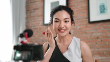 Kadın nüfuzlu kişi canlı yayın yapan video görüntülerini sosyal medya ya da blog üzerinden gözden geçiriyor. Kozmetik stüdyosu ışıklandırmalı mutlu genç kız çevrimiçi pazarlama oturumu yayını için..