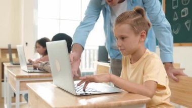 Çeşitli öğrenciler yapay zeka yazılımı kullanırken, Kafkas öğretmeni enerjik çocuğa kodlama konusunda yardım ediyor. Çocuklar oturma ve programlama sistemi. Sevimli bir öğrenci şifreyi öğreniyor. Pedagoji.