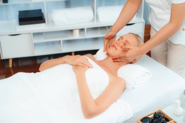 Kafkasyalı kadın stres önleyici kafa masajından ve lüks tatil beldesi ya da otel spa salonundaki modern ışık ortamında yüz güzelliği eğlencelerini şımartmaktan hoşlanıyor. Sessiz.