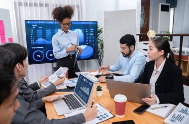 Genç Afrikalı iş kadını modern toplantıda TV ekranında veri analizi paneli sunuyor. Bir grup iş adamıyla konferans odasında iş sunumu. Uyum