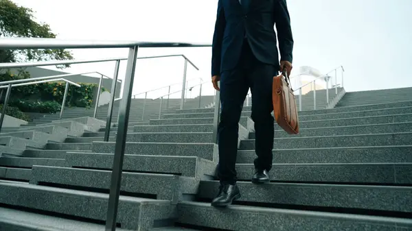Closeup of skilled manager walking down stair with a bag and return to home. Closeup of project manager leg getting fired and walk to dormitory. Investor with untidy suit. Focus on leg. Exultant.