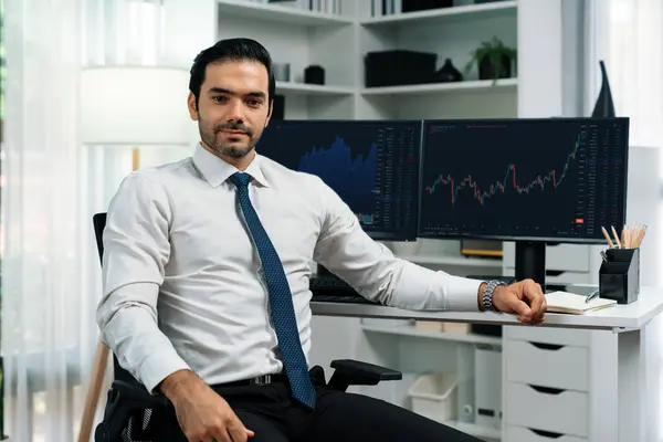 Profile of successful in trader businessman looking at camera with two stock exchange investment screens with good-looking pose in dynamic financial technology graph stock market at office. Surmise.