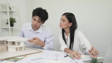 Genç, zeki, yakışıklı mühendis ev modelini ölçerken genç, beyaz, iç tasarımcı önemli noktayı işaret ediyor. Birlikte çalışıyoruz, takım olarak çalışıyoruz. Yaratıcı tasarım konsepti. Tertemiz..