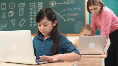 Akıllı Asyalı kız, mühendislik komut yazarken kameraya bakıyor. Çok kültürlü bir öğrenci yapay zekayı öğrenirken öğretmenler sistemi öğretiyor ya da STEM sınıfında sınıfları kontrol ediyor. Pedagoji.