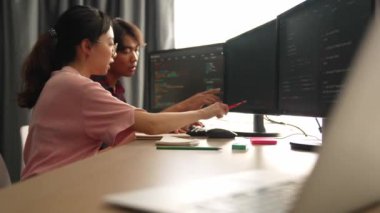 Yavaş çekim arkası yazılım geliştirici mühendisi bilgisayar programlama için birlikte çalışarak hata ayıklama kodunu çözüyor, ofiste monitörde karmaşık algoritmaları çözüyor. Filizlenen