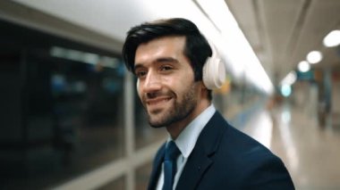 Akıllı bir iş adamı tren istasyonunda kulaklık takarken telefon eder. Profesyonel yönetici, tren ya da metro beklerken pazarlama stratejisi hakkında meslektaşıyla konuşuyor. Sevinçli..