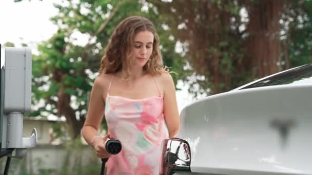 在自然绿色公园的停车场 女服务员正在给电动汽车充电 清洁能源技术用于可持续和生态友好旅行的充电式车辆 太奇怪了 — 图库视频影像