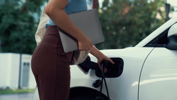 Женщина Подзаряжает Свой Электромобиль Зарядным Устройством Умной Домашней Зарядной Станции — стоковое видео