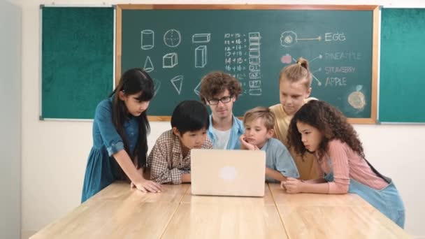 선생님과 교실에서 노트북을 귀여운 다문화 어린이 가르치는 소프트웨어를 프로그램 프로그램에 — 비디오