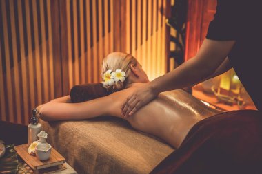 Beyaz kadın müşteri stres önleyici spa masajının keyfini çıkarıyor ve lüks otel ya da otelde sıcak mum ışığında güzellik teniyle eğleniyor. Sessiz.