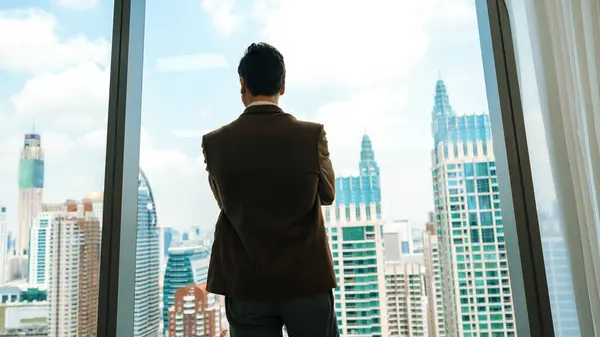 Back View Φιλόδοξος Επιχειρηματίας Στέκεται Στο Διακοσμημένο Γραφείο Ατενίζοντας Έξω — Φωτογραφία Αρχείου