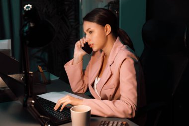 İş kadınının ciddi yüzü, gece ofisinde dizüstü bilgisayarla çalışırken yeni müşteri hedefleri için yaratıcı iş projesi planlaması için müşteriyi arıyor. Varsayım.