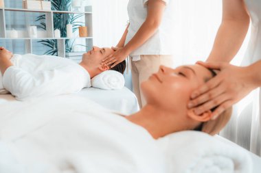 Kafkasyalı çift stres önleyici kafa masajının keyfini çıkarıyor ve lüks otellerde ya da otel spa salonlarında gündüz kaplıcalarında yüz güzelliği eğlencelerini şımartıyor. Sessiz.
