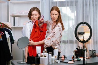 Kadın nüfuzlu kişi video görüntülerini canlı olarak çekiyor. Kıyafetleri sosyal medya ya da blog 'da en üst düzeyde. Stüdyo ışıklandırmalı mutlu genç kız çevrimiçi pazarlama oturumu yayını için..