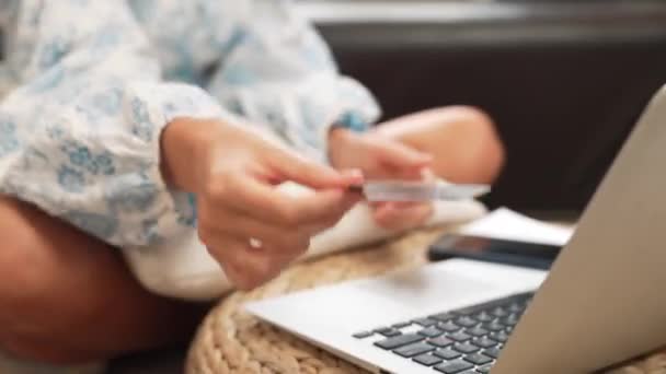 インターネットバンキング用のクレジットカード付きのラップトップを使用している若い女性 自宅でオンライン決済ゲートウェイでオンラインショッピングEコマース デビットカードでオンラインでのモダンで便利な購入 ブリテット — ストック動画