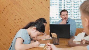 Akıllı öğrenci çalışmalarını kontrol ettiği için mutlu öğretmen diye el kaldırdı. Liseli kız not defterine bakan yetenekli bir öğretmen ve sınıfta onu cesaretlendiren bir başparmak gösteriyor. Yaratıcı. Öğretim