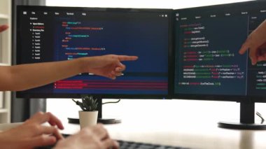 Yavaş çekim arkası yazılım geliştirici mühendisi bilgisayar programlama için birlikte çalışarak hata ayıklama kodunu çözüyor, ofiste monitörde karmaşık algoritmaları çözüyor. Filizlenen