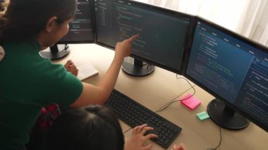Yavaş çekim arkası yazılım geliştirici mühendisi bilgisayar programlama için birlikte çalışarak hata ayıklama kodunu çözüyor, ofiste monitörde karmaşık algoritmaları çözüyor. Filizlenen