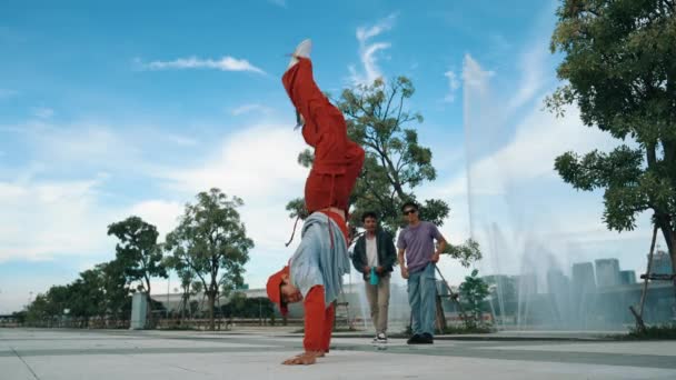 亚洲技术高超的嬉皮士在镜头前做着冰冻姿势 周围是带着天空背景的喷泉附近的霹雳舞蹈队 一群英俊的人在练习男孩舞 2024年户外运动 神气活现 — 图库视频影像