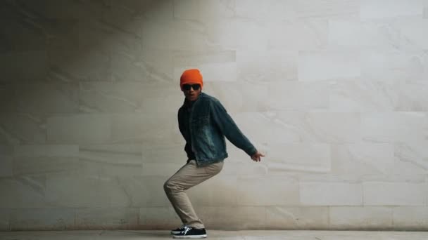 专业的亚洲嬉皮士在灰色背景下表演霹雳舞 街头舞蹈演员穿着时髦的嘻哈服装 跳着时髦的音乐 练习嘻哈脚步声 2024年户外运动 神气活现 — 图库视频影像