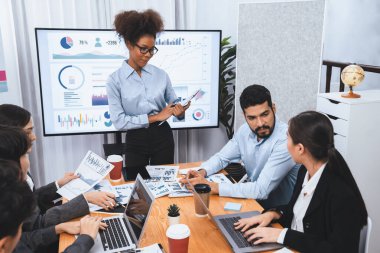 Genç Afrikalı iş kadını modern toplantıda TV ekranında veri analizi paneli sunuyor. Bir grup iş adamıyla konferans odasında iş sunumu. Uyum