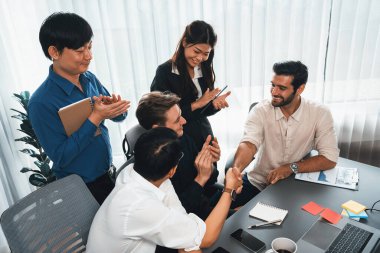 Çeşitli ofis çalışanları stratejik iş pazarlama toplantısı üzerine anlaşma yaptıktan sonra el sıkışıyor. Takım çalışması ve olumlu tutum verimli ve destekleyici bir iş yeri yaratır. Tedbirli