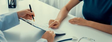 Klinikteki ya da hastane ofisindeki doktor randevusuna katılan hasta, tıbbi tedavi seçeneklerini tartışıyor ve muayene sonuçlarını ya da hastalıkla ilgili tıbbi kayıtları açıklıyor. Panorama Katı