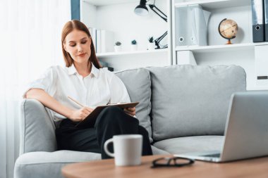 Klinikteki psikolog kadın. Profesyonel portresi. Dostane gülümsemesiyle hastayı psikoloğa davet ediyor. Tecrübeli ve kendine güvenen psikolog son derece uzmandır.