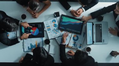 Profesyonel iş adamının yukarıdan aşağıya havadan bakış açısı veri yatırımı grafiğini analiz etmek için finansal istatistik dağıttı. Çeşitli yatırımcıların oluşturduğu bir grup pazarlama stratejisi üzerinde çalışıyor. Müdürlük.