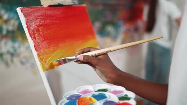 Zbliżenie Afrykańskiego Chłopca Ręcznie Malować Płótno Ciepłym Kolorem Tonu Podczas — Wideo stockowe