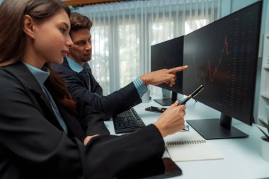 Dinamik borsada döviz kuru yatırımını tartışan iki ticaret simsarı iki bilgisayar ekranında gerçek zamanlı risk grafiği ya da modern ofisteki kar noktasını karşılaştırıyor. Varsayım.