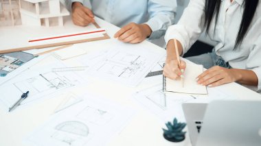 Profesyonel mühendis ev modelini tartartarken, yetenekli tasarımcı da planına yazar. Birlikte çalışmak, işbirliği, işbirliği. Yaratıcı tasarım ve takım çalışması konsepti. - Yakın çekim. Tertemiz.