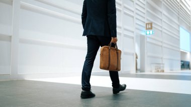 Profesyonel iş adamının bacağını tutarken yakın plan fotoğrafı. Proje yöneticisinin bacağa odaklanmış görüntüsü. Seyahat, taşınma, yolculuk, yürüyüş, yeni bir pozisyon alma, iş değiştirme. Sevinçli..