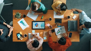 Akıllı iş adamlarının en iyi görüşü pazarlama fikrini toplantıda sunarken, bir grup yatırımcı da hisse senedi piyasası şeması veya veri analizine bakarken strateji dinleyip planlıyorlar. Üst Manzara. Cemaat.