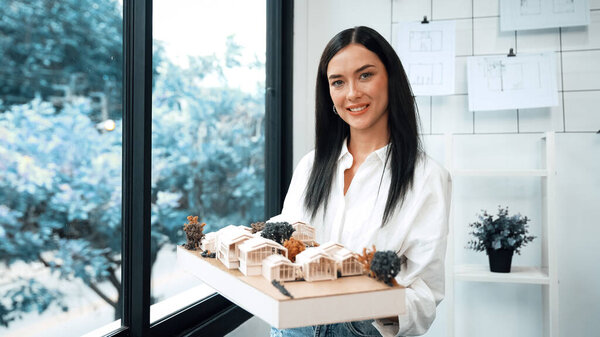 Крупный план квалифицированного молодого красивого кавказского архитектора лифта дом модели левой и правой стороны, чтобы проверить и сосредоточиться на проверке ошибок точки в современном офисе с чертежом. Непорочный.