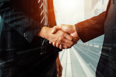 Arka planda iş adamları el sıkışma çift pozlama görüntü iş anlaşmasının ortaklık başarısını gösteren. Kurumsal ekip çalışması, güven ortağı ve iş sözleşmesi kavramı.