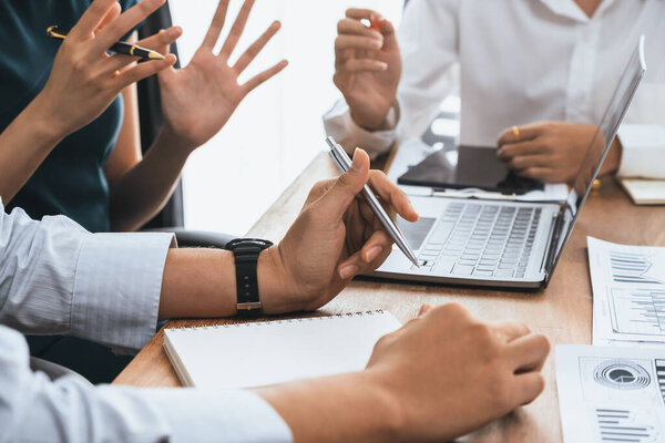 Diverse business people work together, discuss in corporate office. Professional teamwork discussing and pointing at laptop. Modern multicultural office worker. Concord