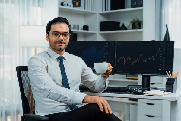 Profile of successful in trader businessman looking at camera with two stock exchange investment screens with raising fist up and thumb up in dynamic financial technology graph stock market. Surmise.