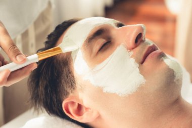 Kaplıca salonunun sakin atmosferi, insan müşterisi modern gün ışığında lüks yüz kremi masajıyla kendini yenileme zevkine kapılıyor. Yüz bakımı ve güzellik konsepti. Sessiz.