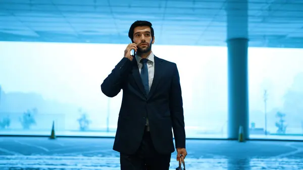 Project manager phone calling to colleague while standing in front of door with blue filter. Smart business man talking or discussing about marketing plan with business team by using phone. Exultant.