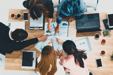 Modern ofisteki iş adamları ve iş kadınlarıyla grup toplantısındaki iş adamlarının en üst düzey görüşü, masada dizüstü bilgisayar, kahve ve belge ile. Kurumsal şirketler uds