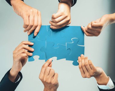 Üst düzey panorama panorama iş adamlarının masa üzerinde yapboz yapbozu yapmaları, iş ortaklığını ve insan kaynakları için kolektif takım çalışmasını ve iş arayan geçmişini sembolize ediyor. Kurnaz.