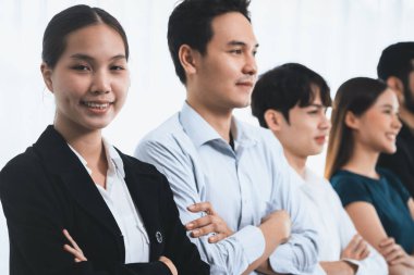 Profesyonel iş adamlarından oluşan çeşitli gruplar modern kurumsal ofiste çapraz kol hareketi ile sırada bekliyor. Mutlu ve gülümseyen, çok ırklı ofis çalışanı ekip birleşmesi ve birlikte başarılı. Uyum